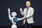 SoftBank Corp. Chief Executive Masayoshi Son waves with the company’s human-like robots during a news conference in Urayasu