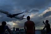 Pessoas olham um avião da GOL Linha Aéreas decolando do Aeroporto Santos Dumont no Rio de Janeiro